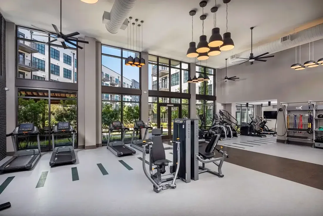 A wall of floor-to-ceiling black-framed windows in the fitness center at 565 Hank in Summerhill, Atlanta