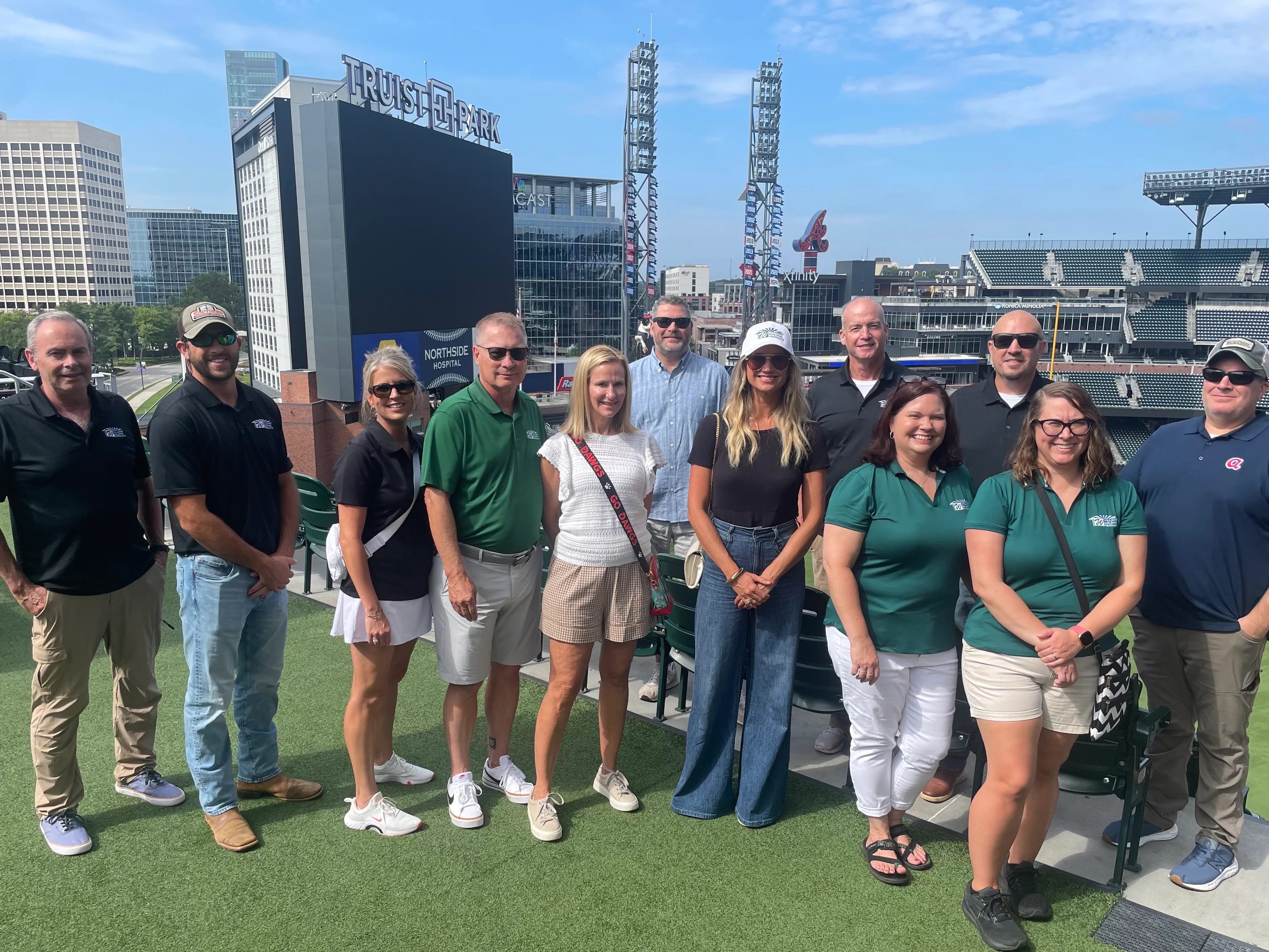 About a dozen members of the Williams Building Products team, many in green company polos, at Truist Park