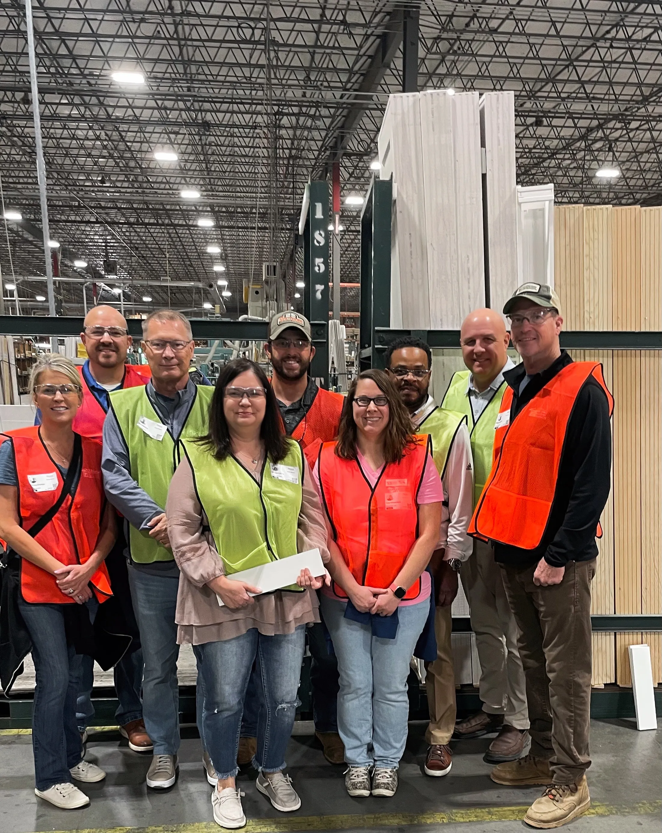 The Williams Building Products team in safety vests on a tour of a window manufacturing plant
